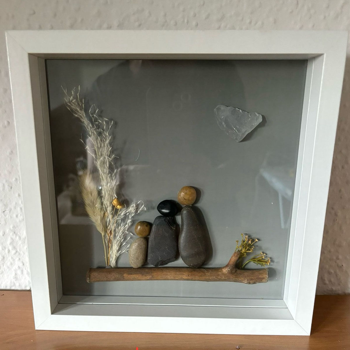 Bild mit Steinen und Holz im Rahmen