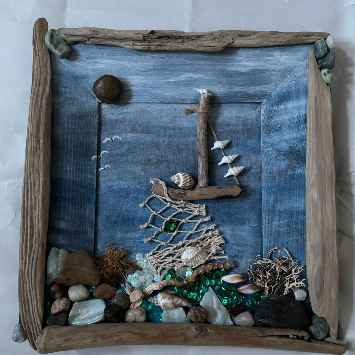 Maritimes Holzbild mit Steinchen und Seilen